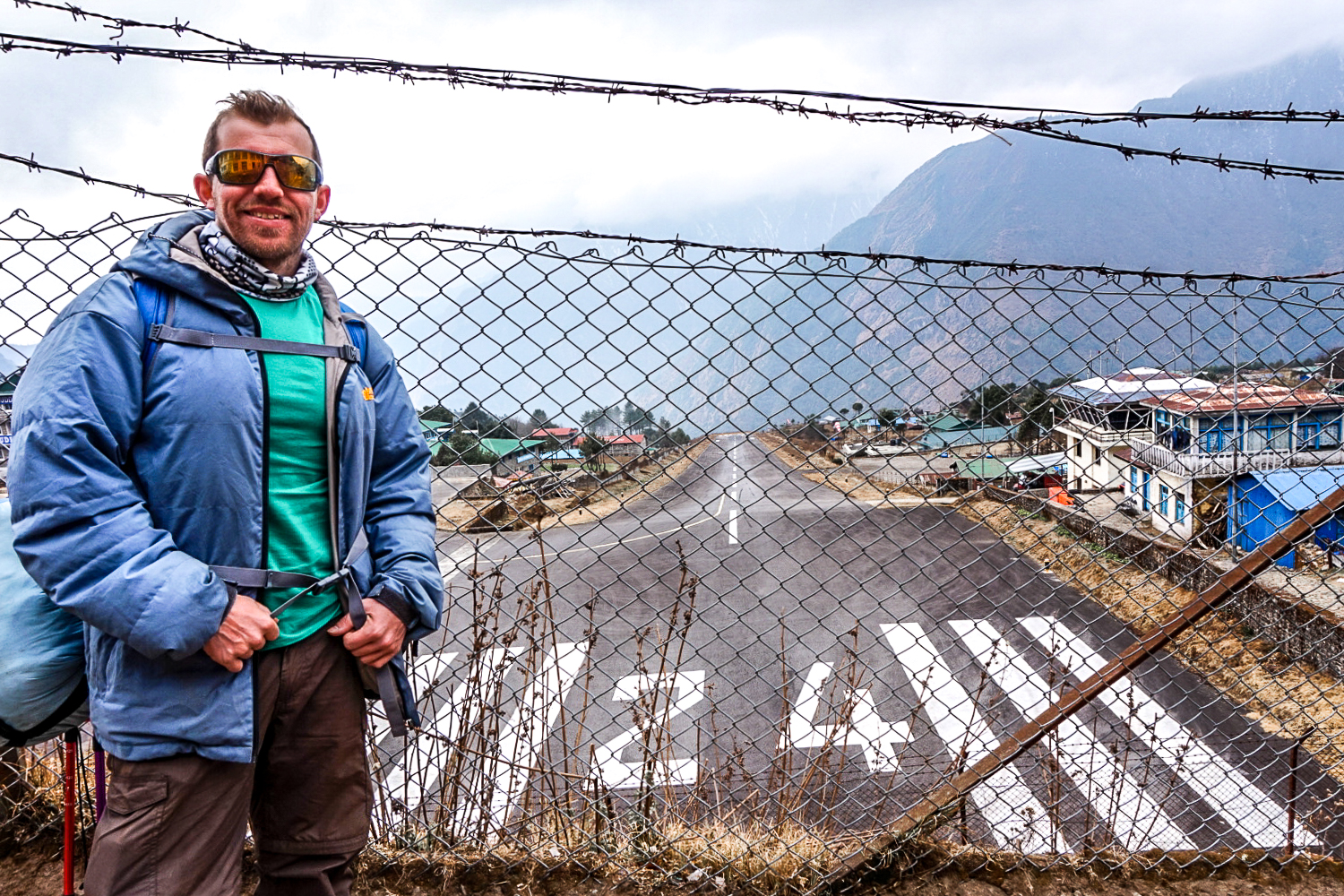 A man stood at the tiny runway at Lukla airport which is on a decline