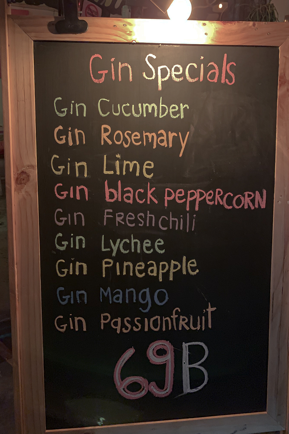 A "Gin specials" chalkboard price list in Thailand