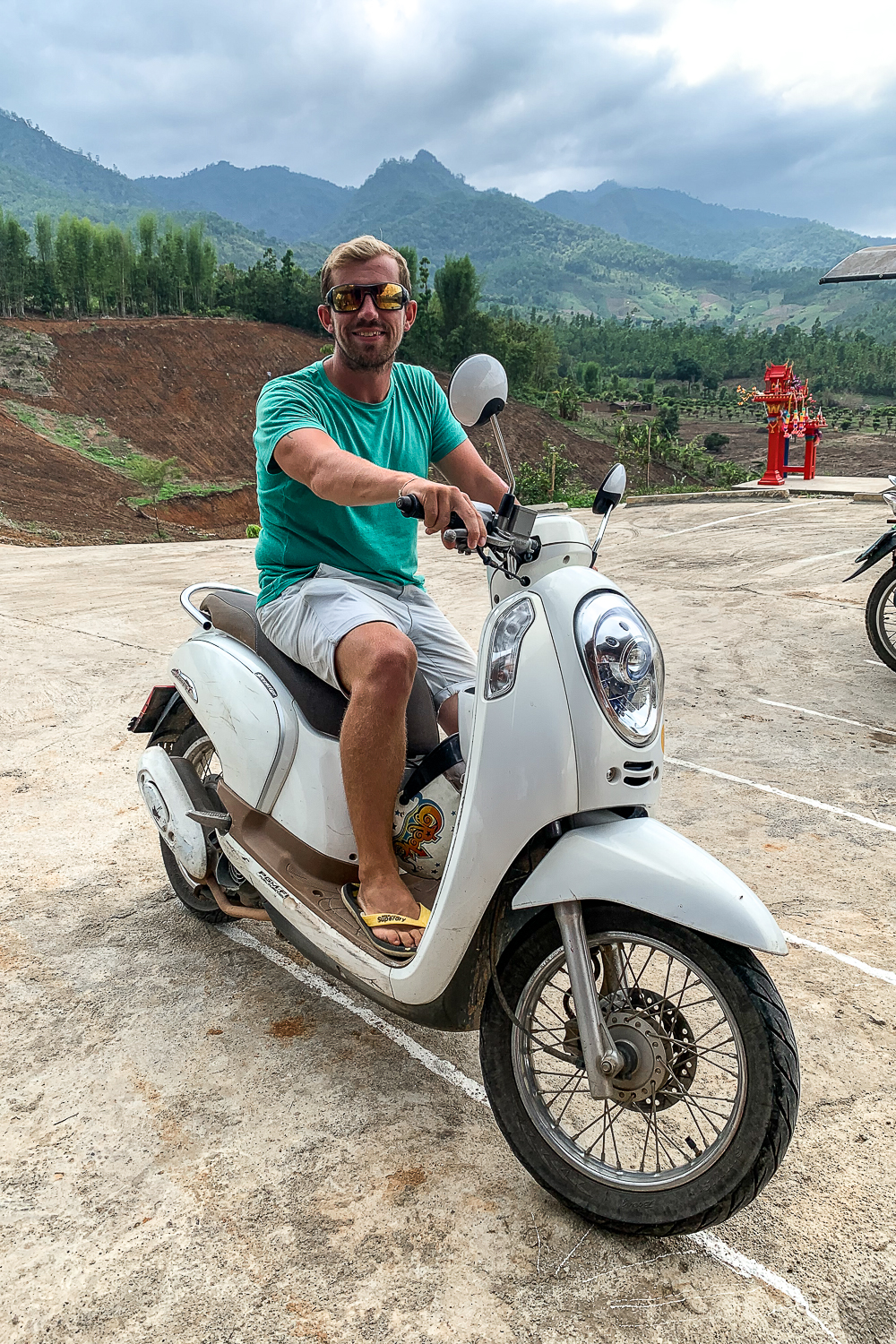 A guy sitting on a petrol scooter
