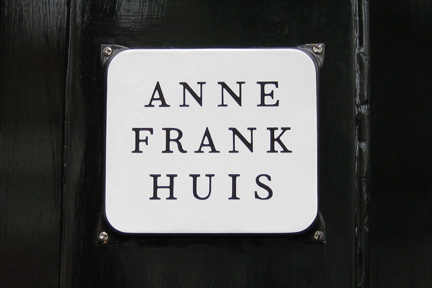 The sign outside Anne Frank's house, a white sign with the words 'ANNE FRANK HUIS' written in black, block capitals