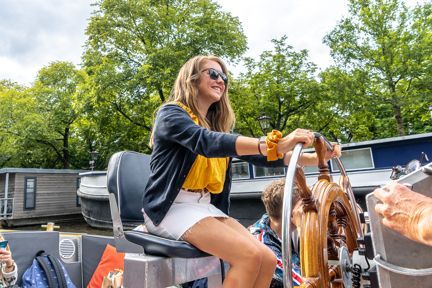 Girl steering a canalboat in Amsterdam