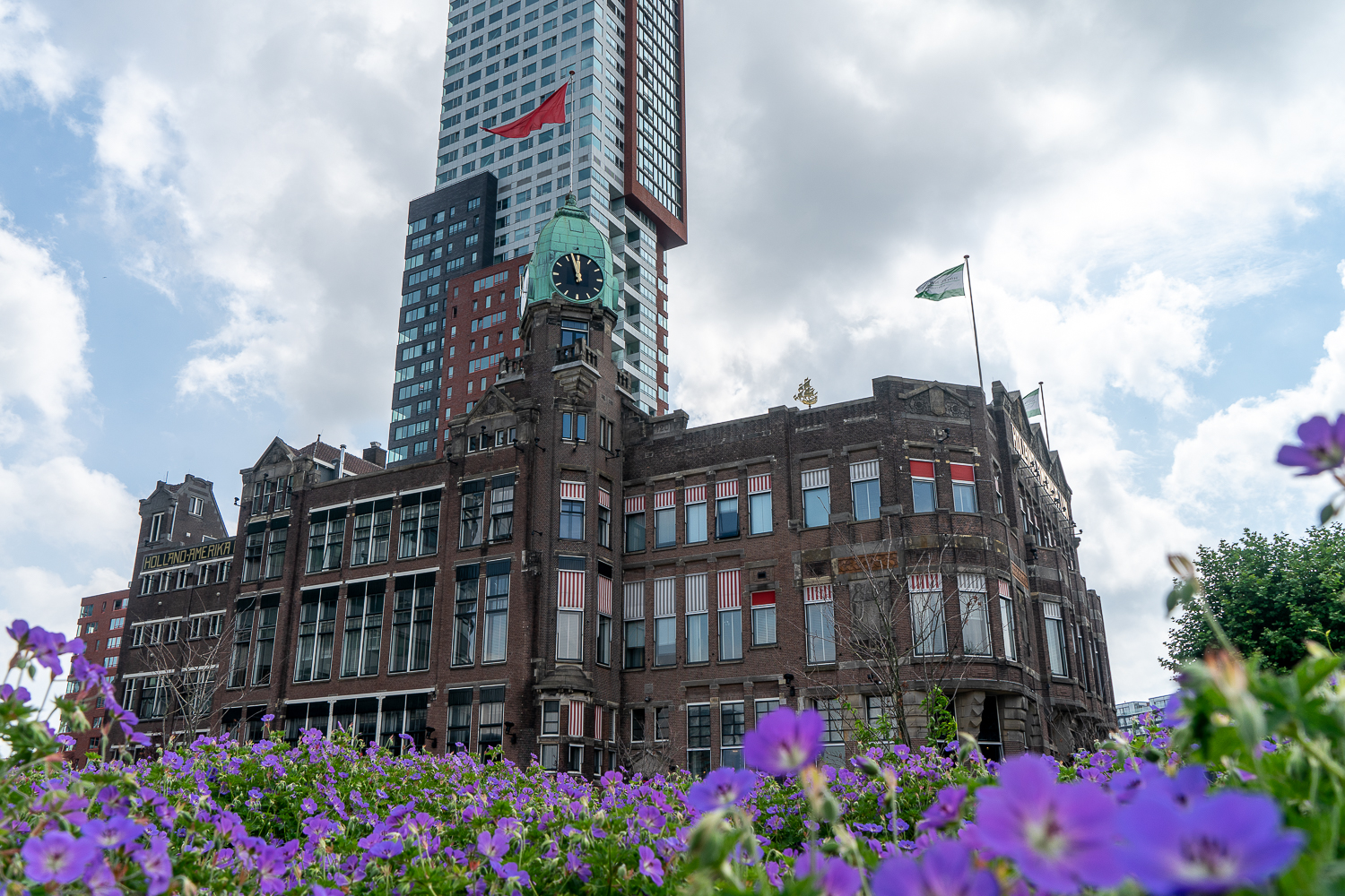 New York Hotel in Rotterdam - an iconic looking brown brick building with copper clock tower and red and white shutters