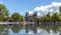 Wide view of the Rijksmuseum in Amsterdam with water and reflection in the foreground