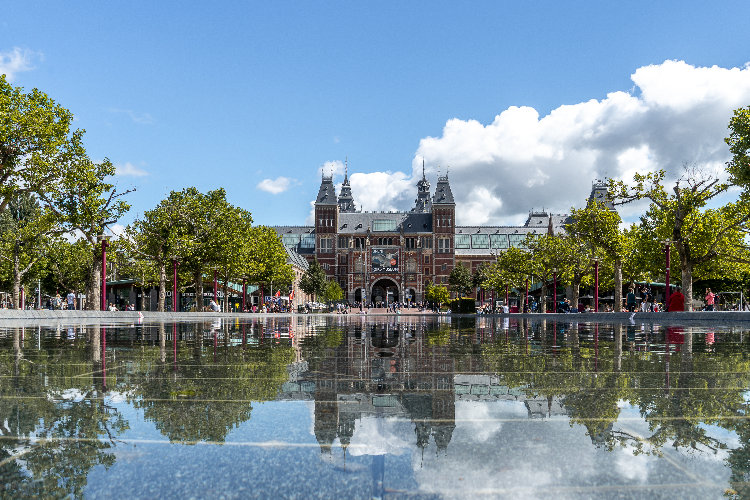 Wide view of the Rijksmuseum in Amsterdam with water and reflection in the foreground