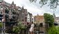 Girl standing by the canals in Rotterdam with bicycles and narrow houses