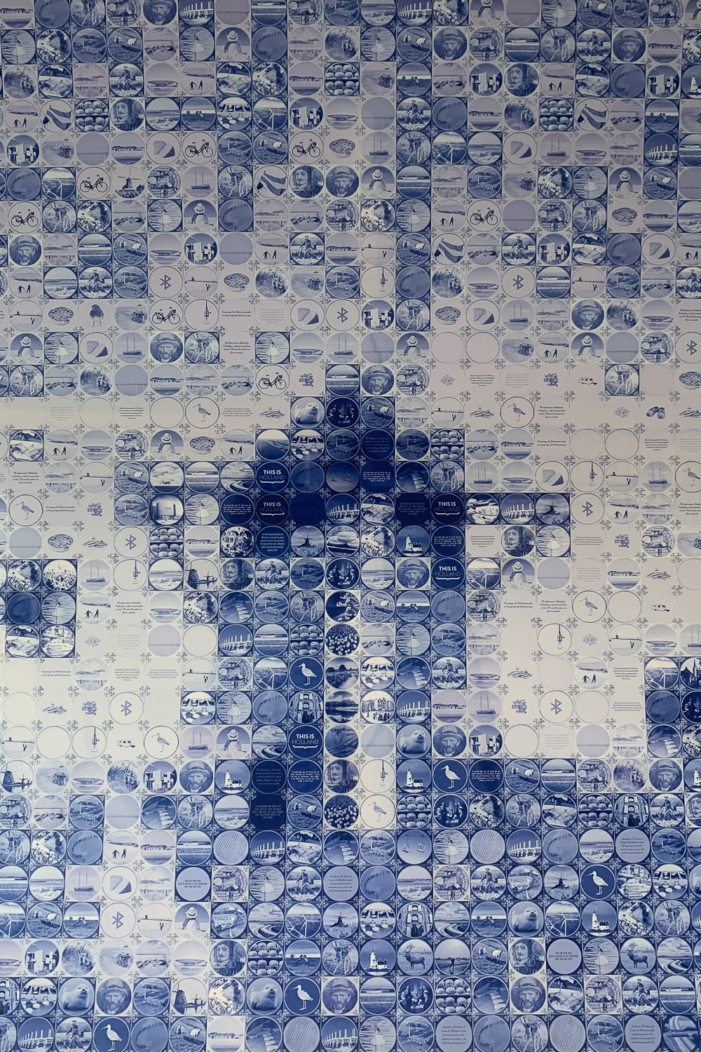 A blue and white ceramic tile mosaic of a Dutch windmill