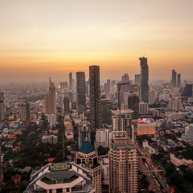 A high up view over Bangkok skyline with skyscrapers and parks