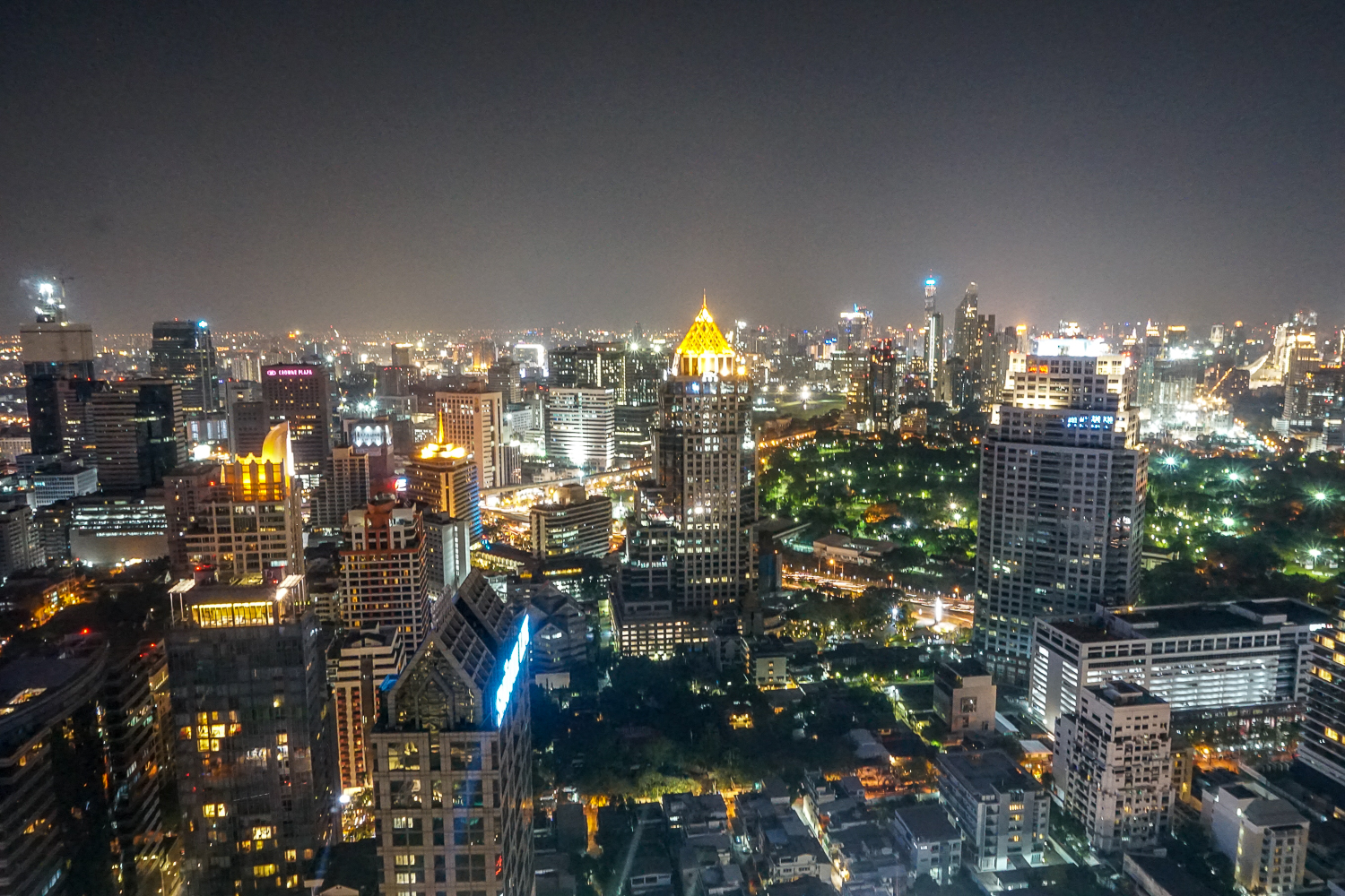 A view from high up in Bangkok at night - skyscrapers and parks