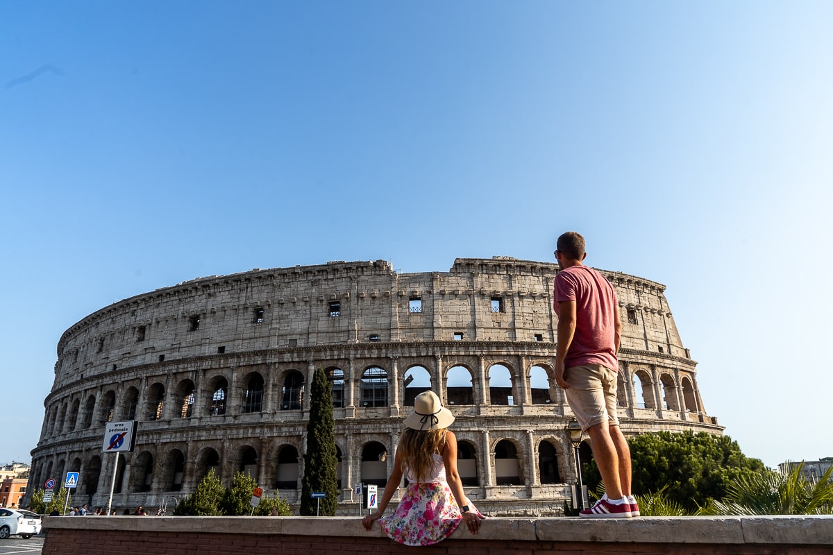 A couple captivated by the iconic Colosseum in Rome, representing their awe for its historical and cultural significance.