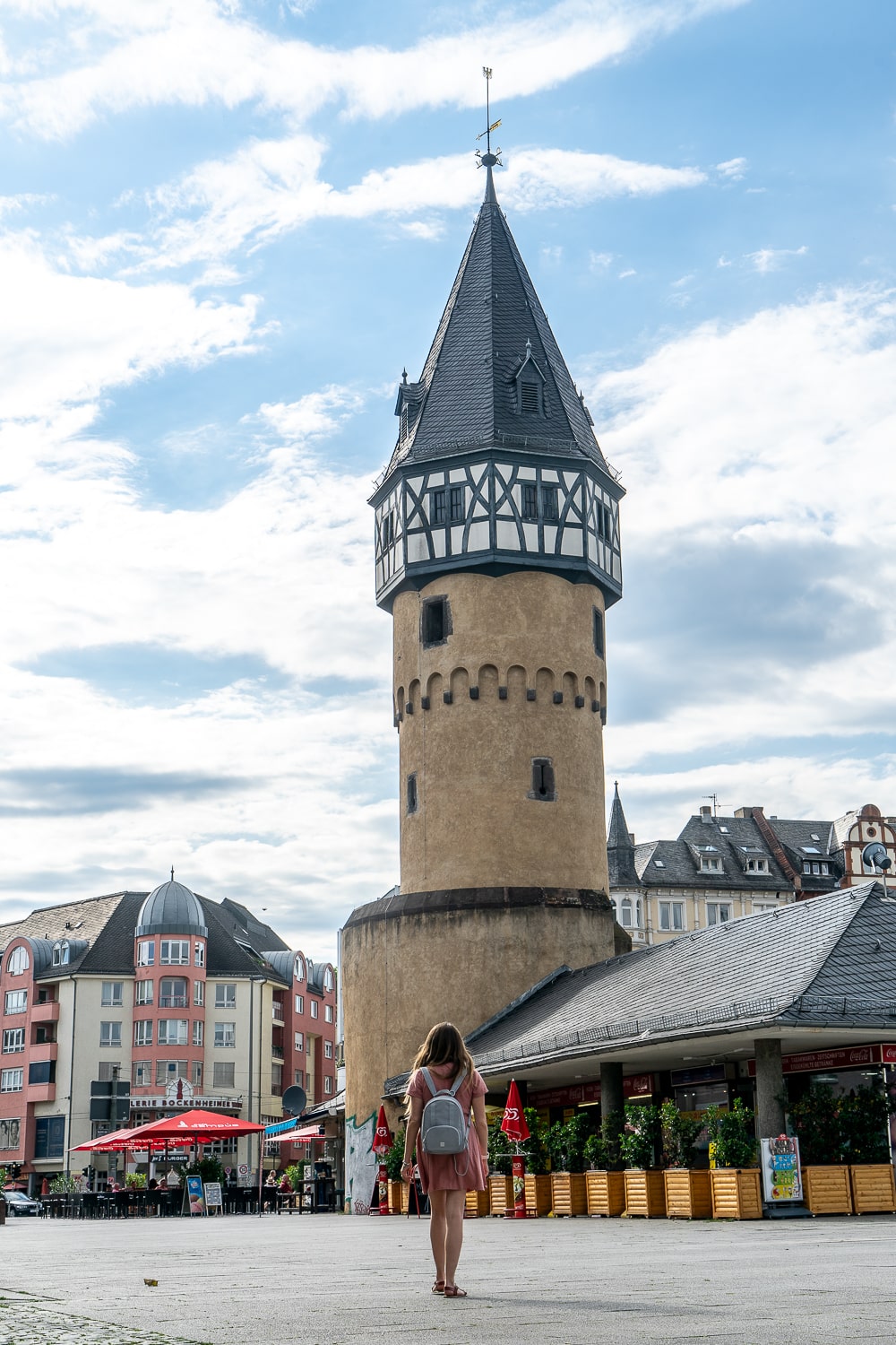 A girl walking towards a fairy tale style castle tower