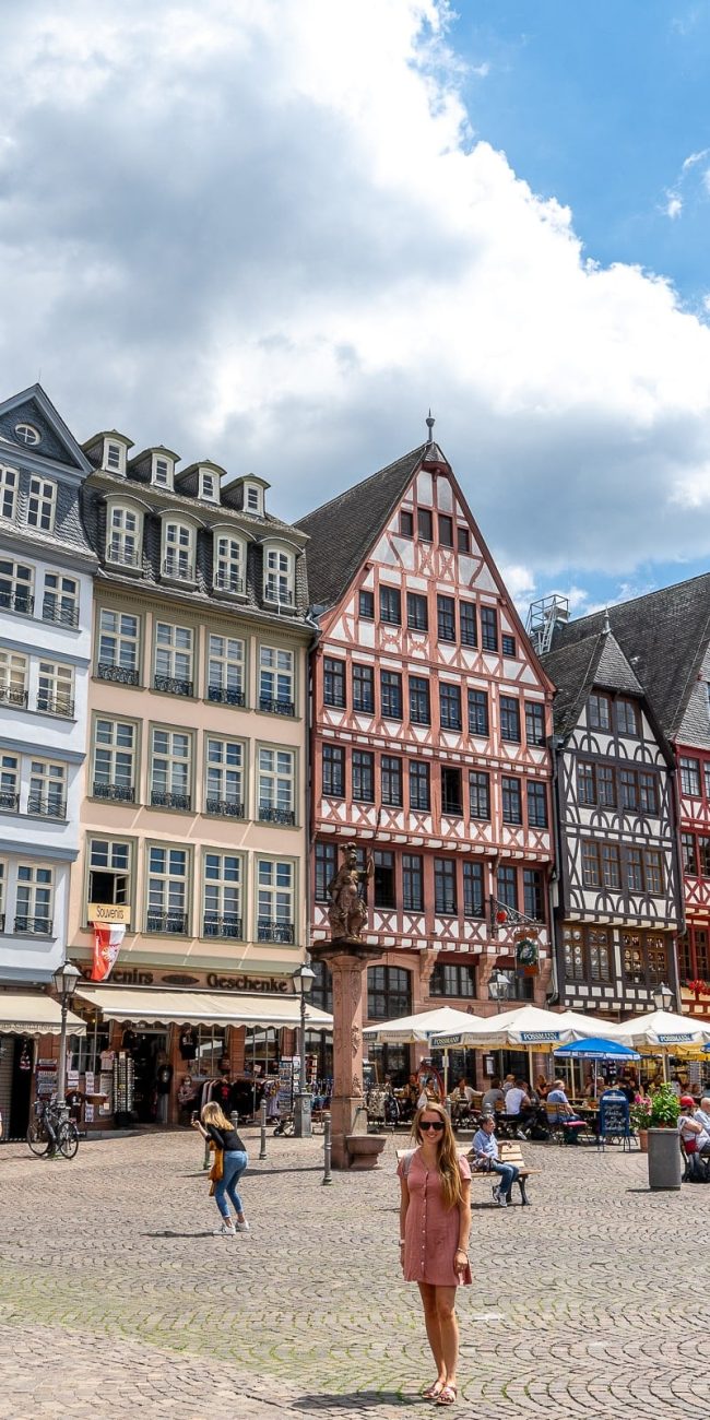 The old town in Frankfurt with colourful, late gothic style buildings and a girl standing in the square