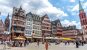 The old town in Frankfurt with colourful, late gothic style buildings and a girl standing in the square
