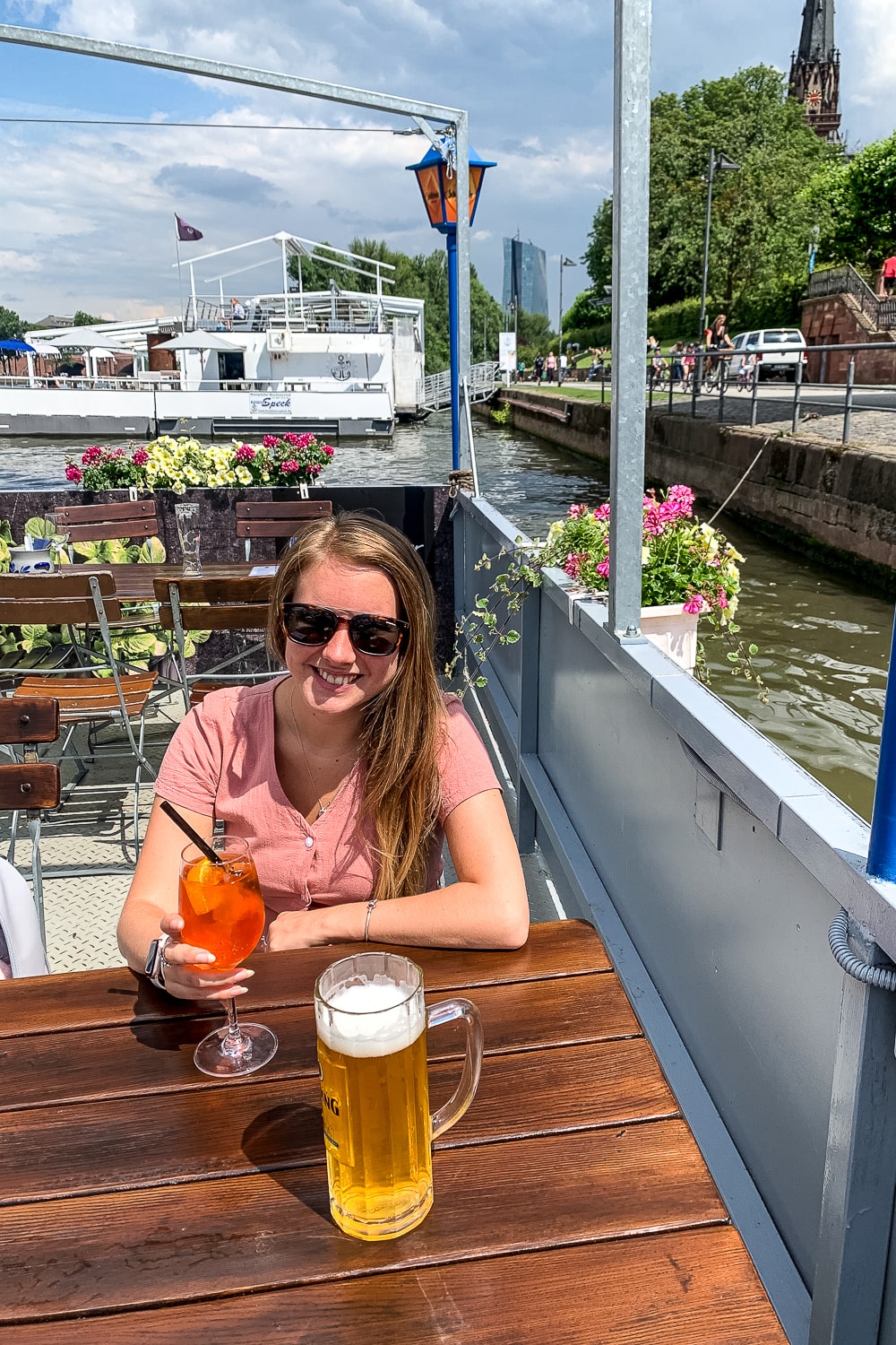 A girl sat on a boat restaurant with drinks