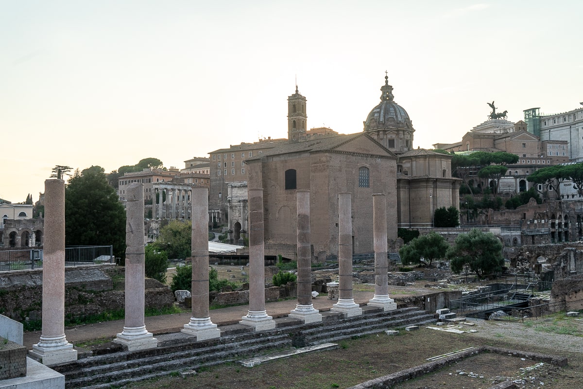 The Roman Forum at sunset - a stunning view of ancient ruins bathed in warm, golden light.