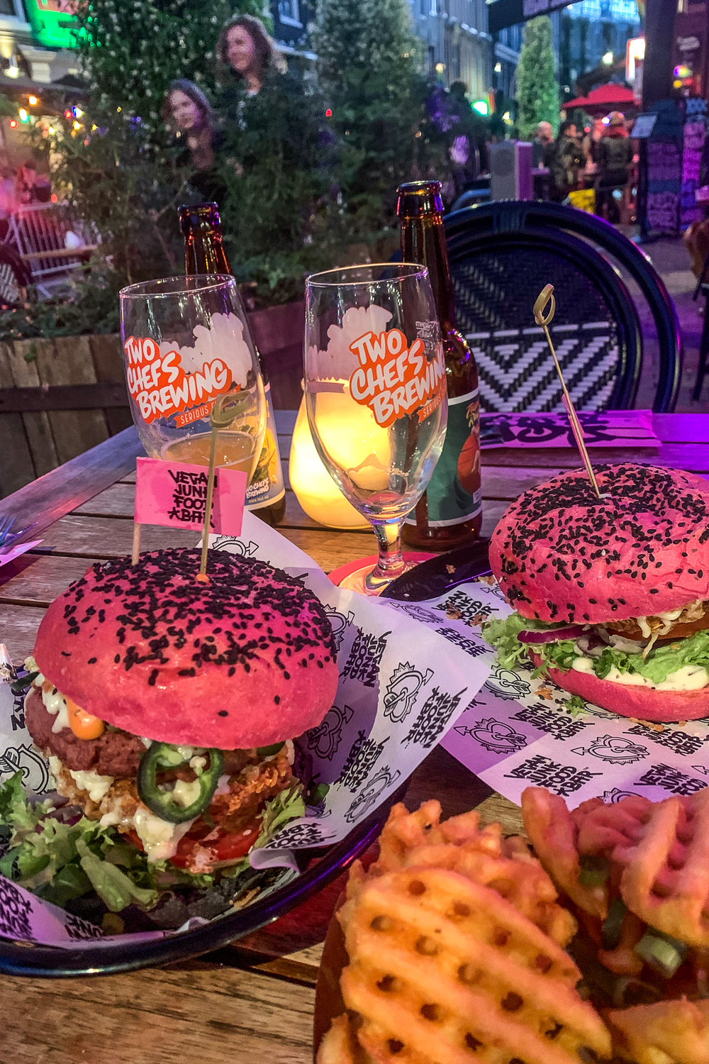 Burgers in pink buns, waffle fries and craft beers with pink lighting