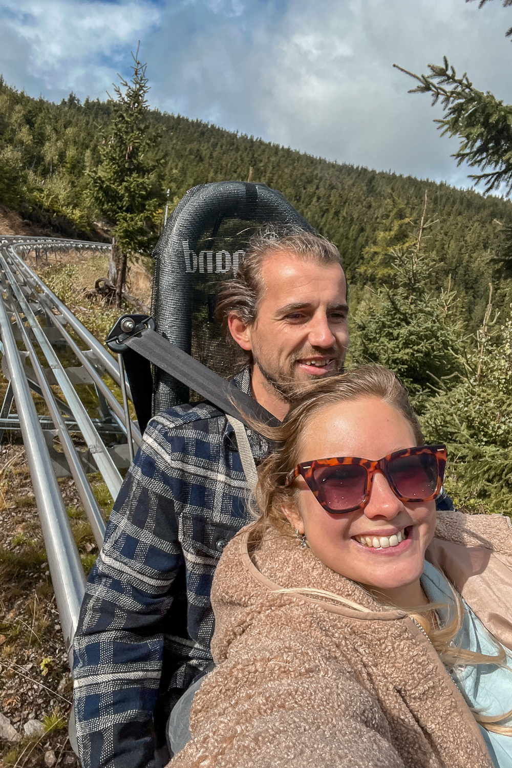 A couple riding an alpine coaster in the Czech mountains