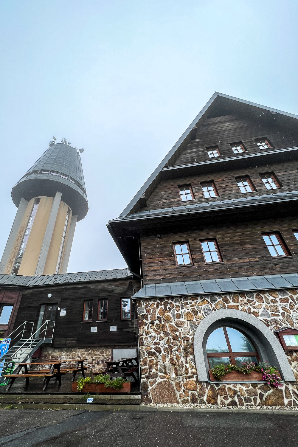 Cloudy view of cabin style restaurant with a tower in the background