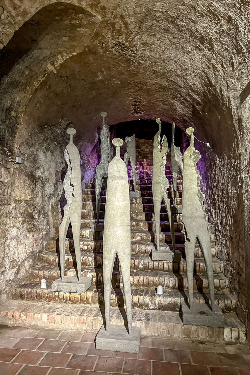Eerie looking humanoid sculptures in a castle dungeon or cellar