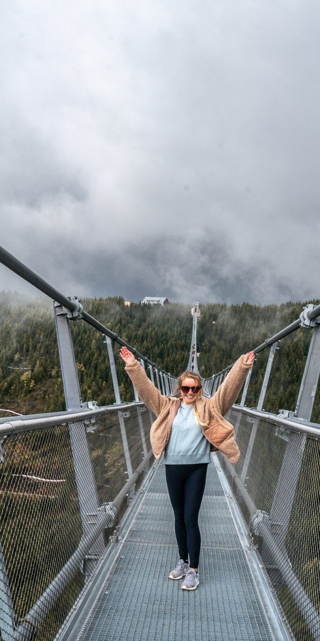 Girl standing with her arms up on the Skybridge721 in Dolni Morava