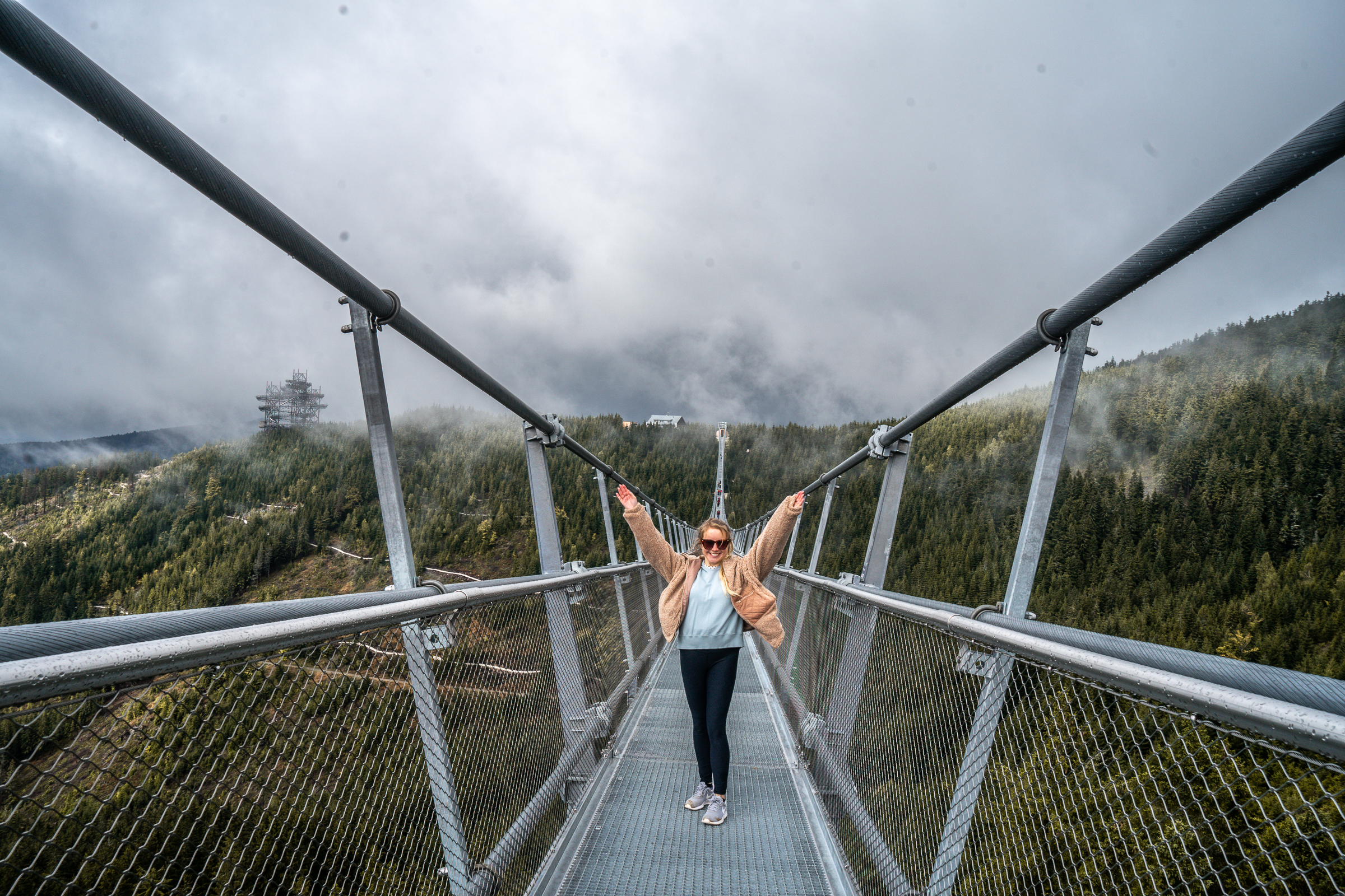 Girl standing with her arms up on the Skybridge721 in Dolni Morava
