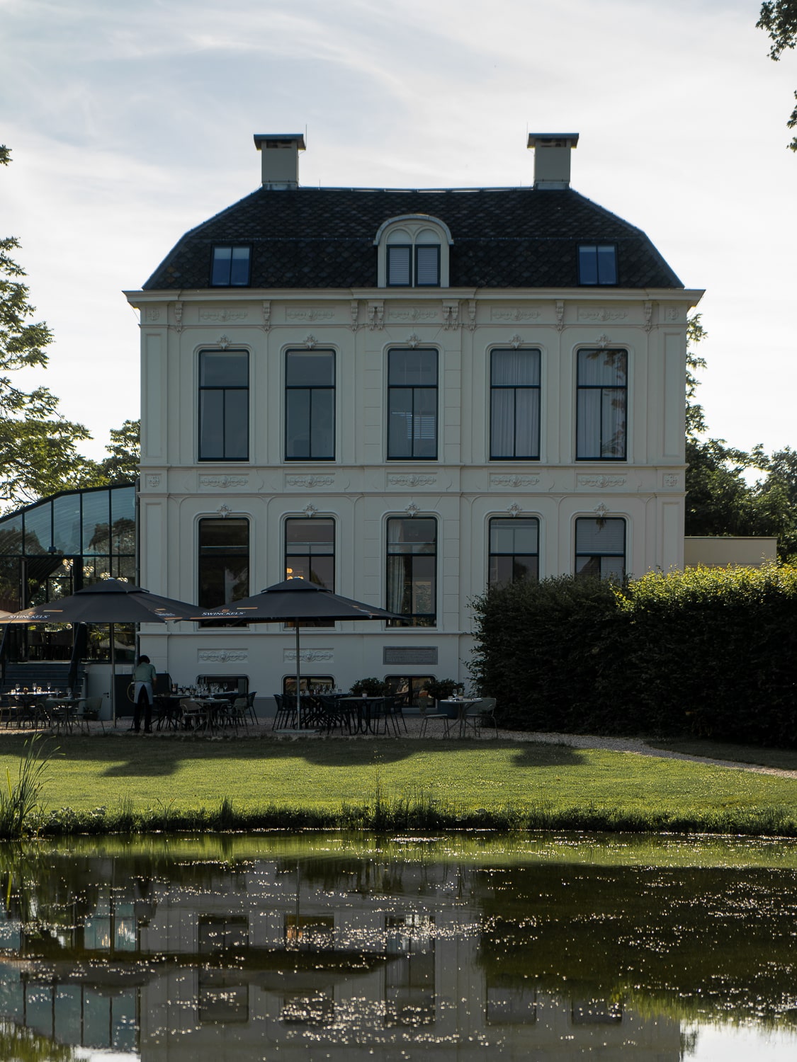 A white country estate with a lake