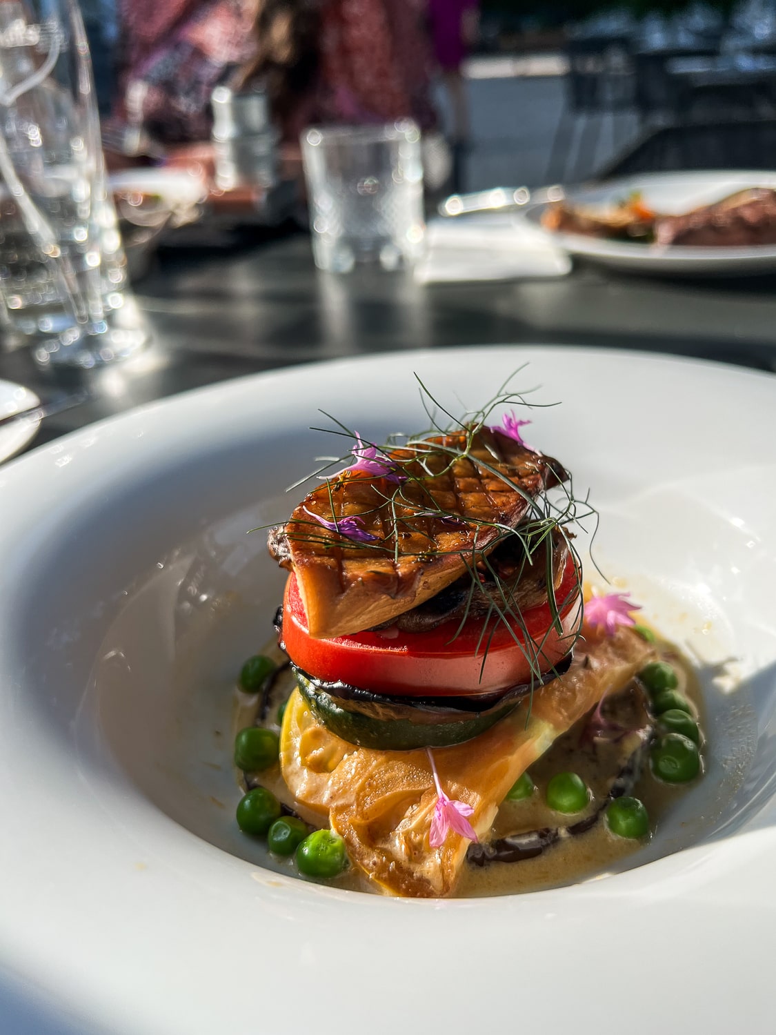 A colorful tall dish of mushroom and vegetables in a fine dining restaurant