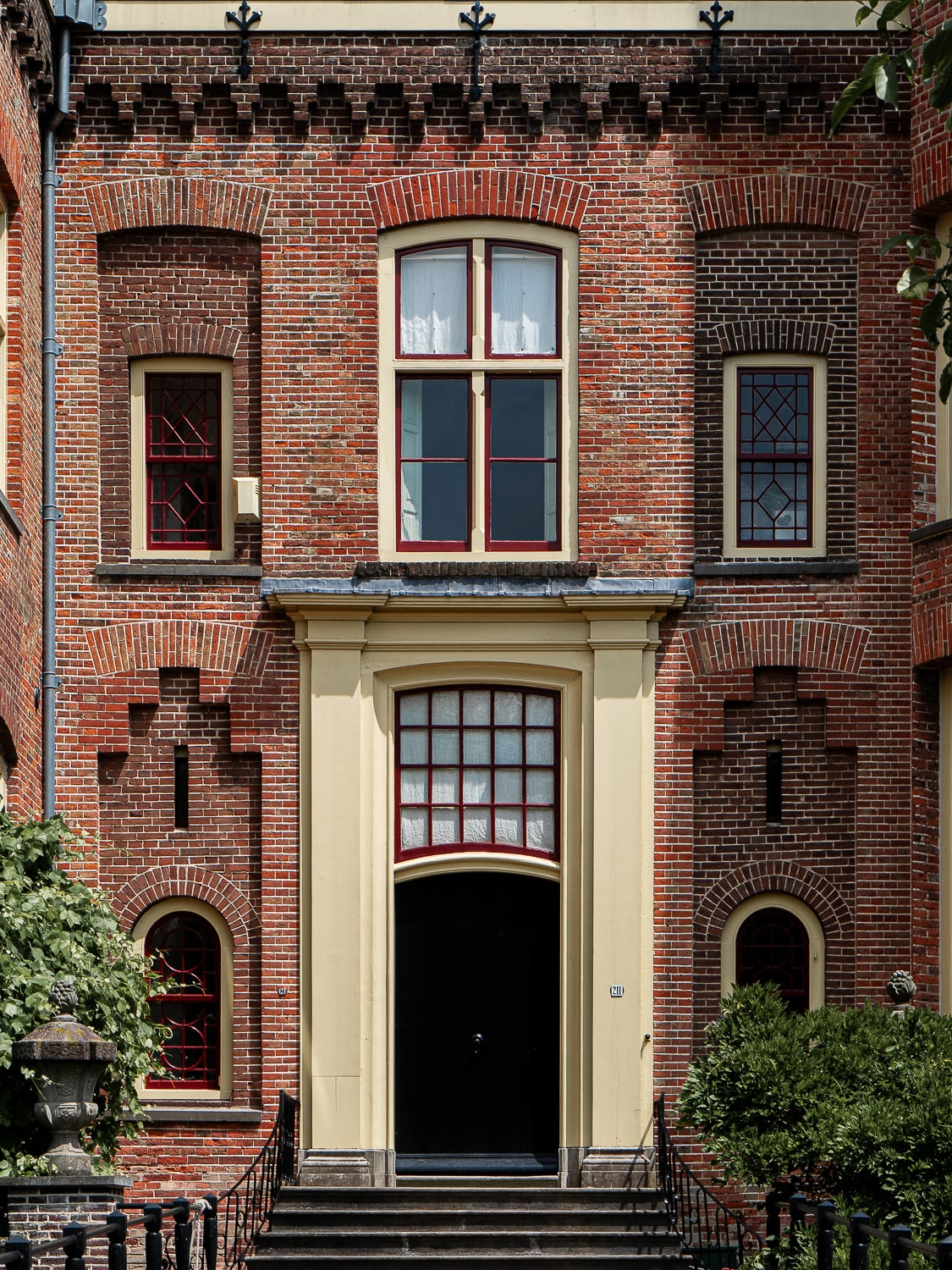 A red brick castle doorway with a black door