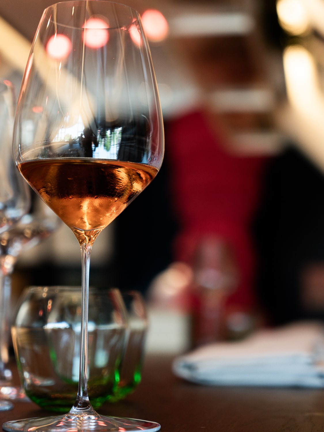 A wine glass with a pinkish coloured infused tea drink