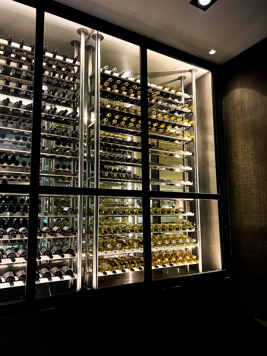 A large wine rack with hundreds of bottles of red and white wine