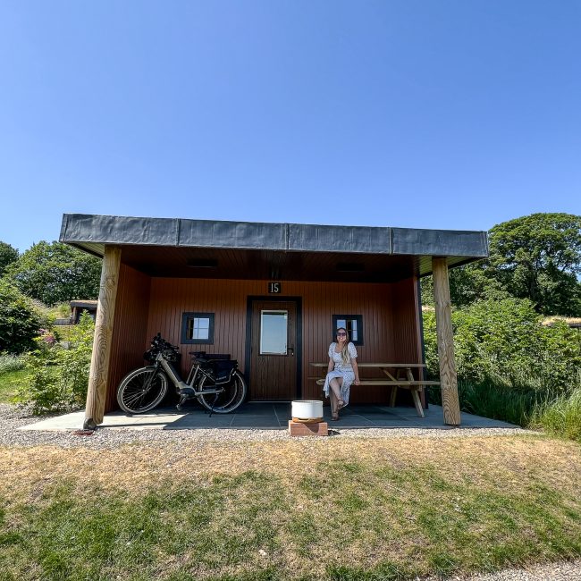 a woman sat outside a glamping house
