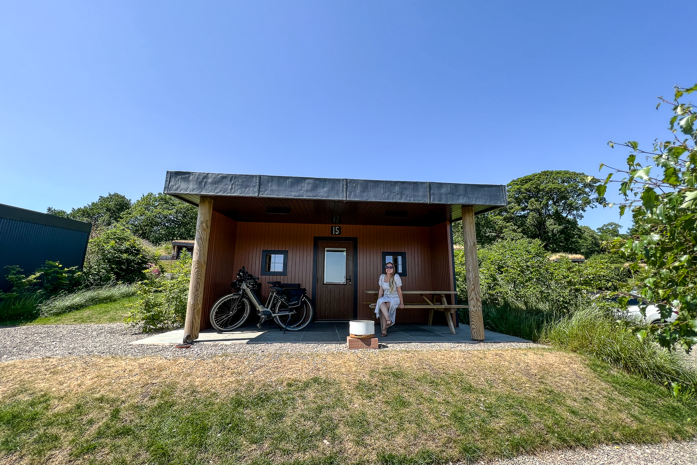 a woman sat outside a glamping house