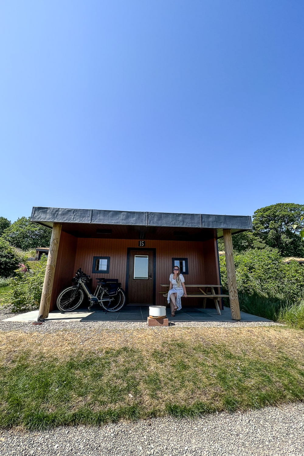 a girl sat outside a small glamping house