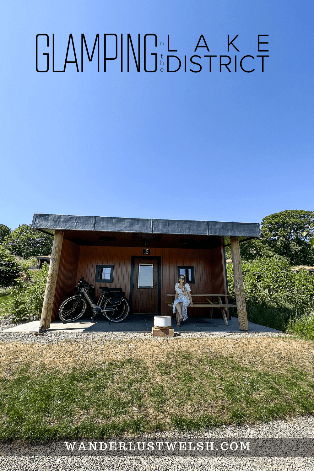 a woman sat outside a glamping house with a barbecue and e-bike