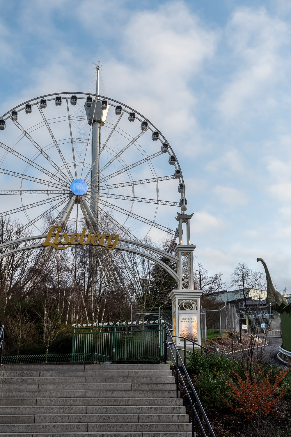 Liseberg amusement park from the outside featuring a big wheel and a large model dinosaur