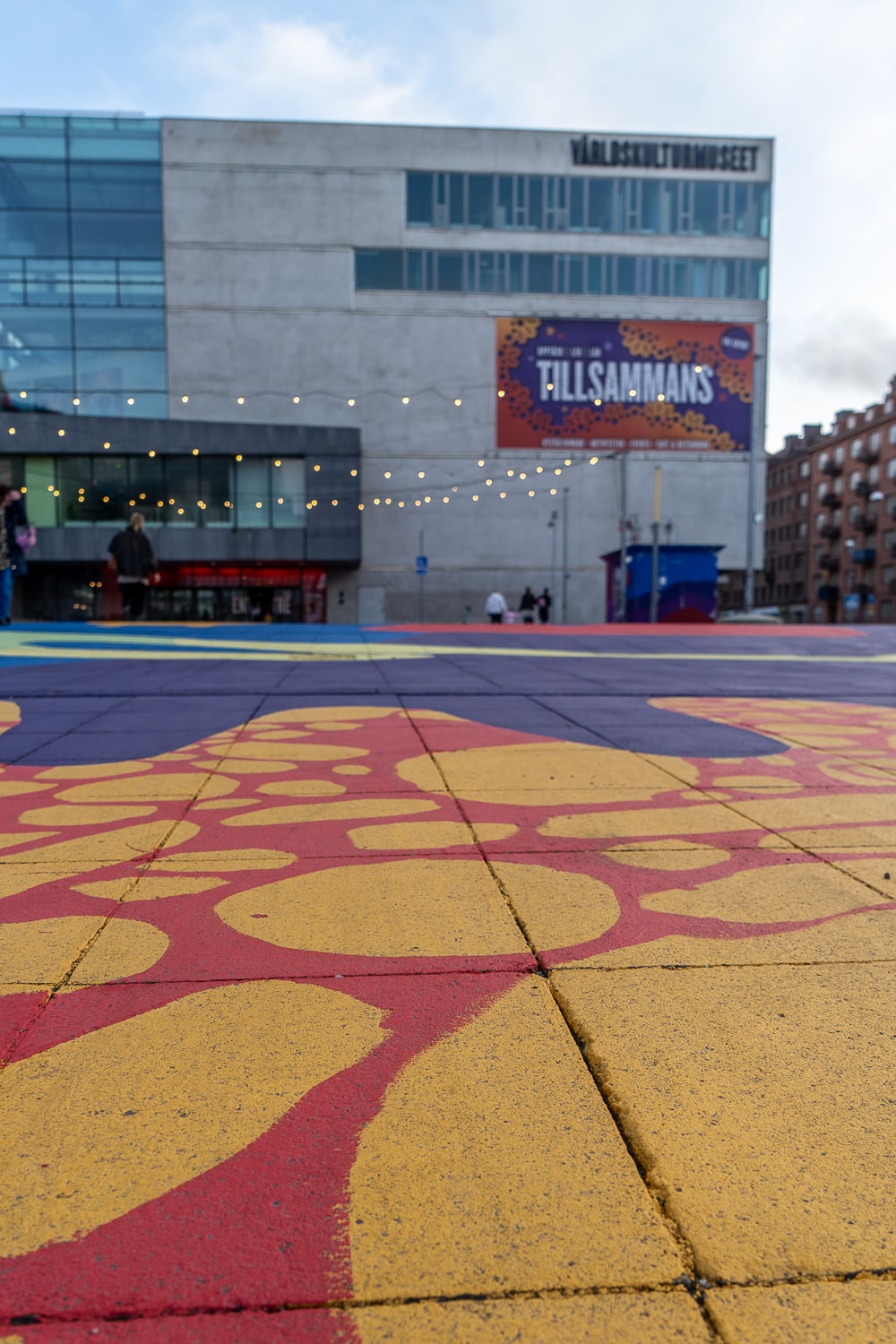 A colourful yellow, red, and blue painted floor outside a museum