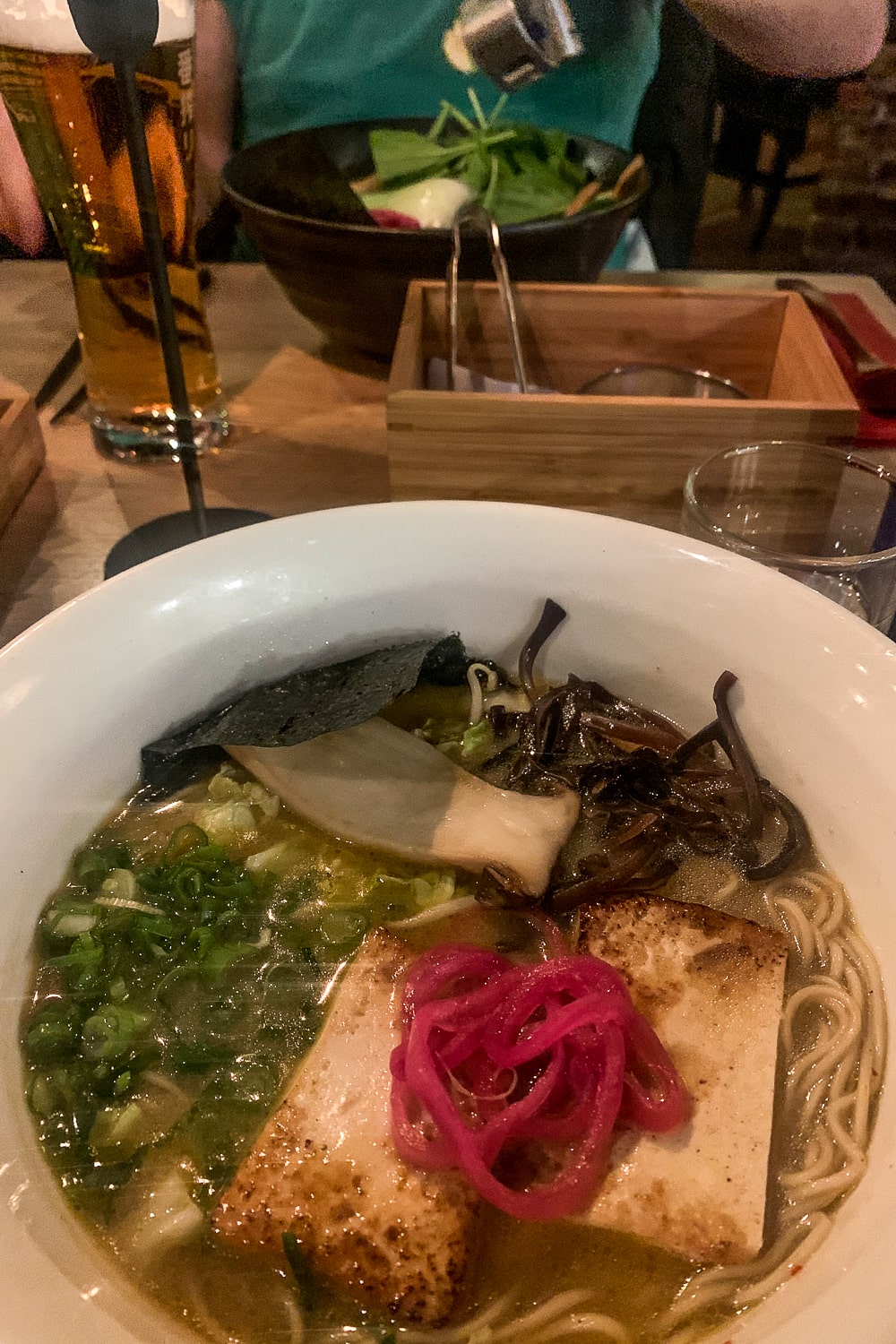 A bowl of ramen including tofu, chillies, king oyster mushroom and nori seaweed