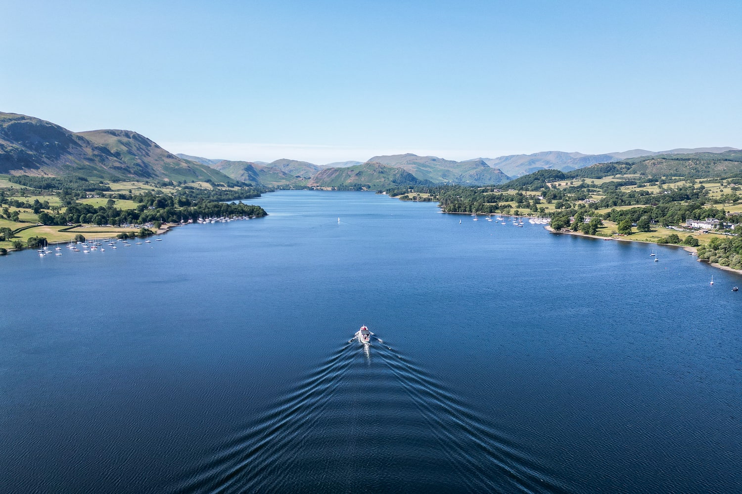a drone shot of a steam boat on a lake