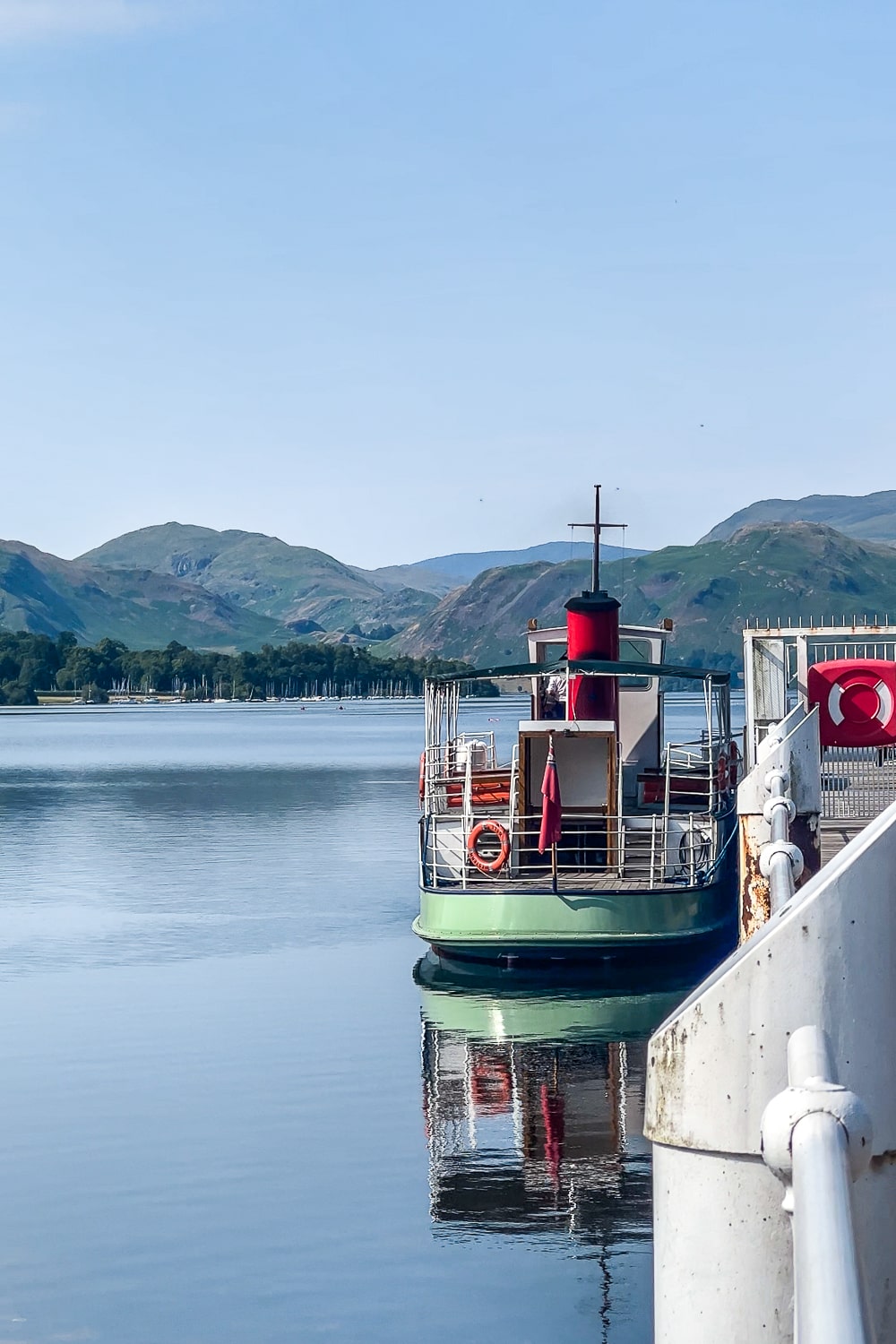 a steam boat on a lake near the pier