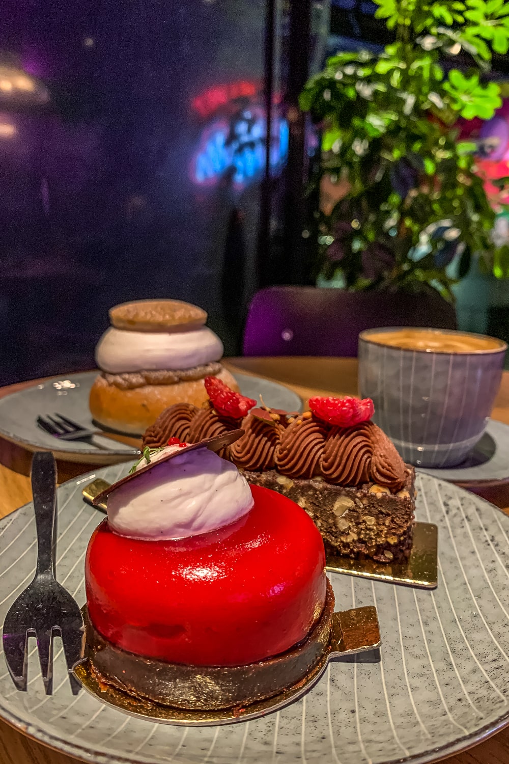A selection of colourful, indulgent cakes and a coffee