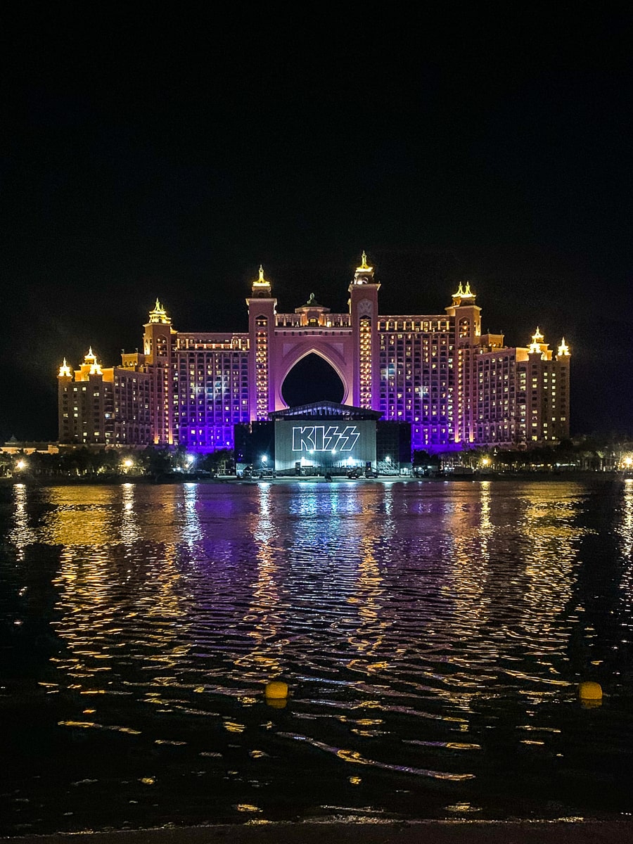 The Atlantis Hotel in Dubai at night, lit up, reflecting on the water in front of it