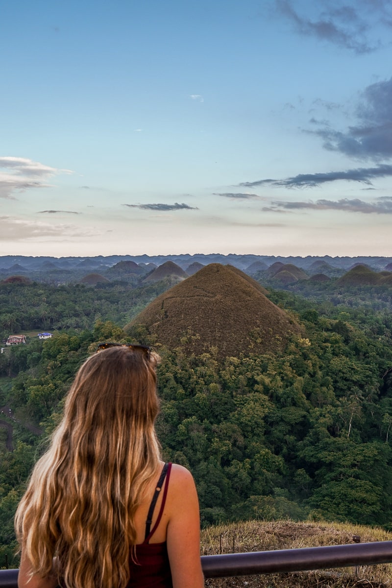 A woman at a chocolate hills viewpoint in Bohol - oddly shaped brown hills
