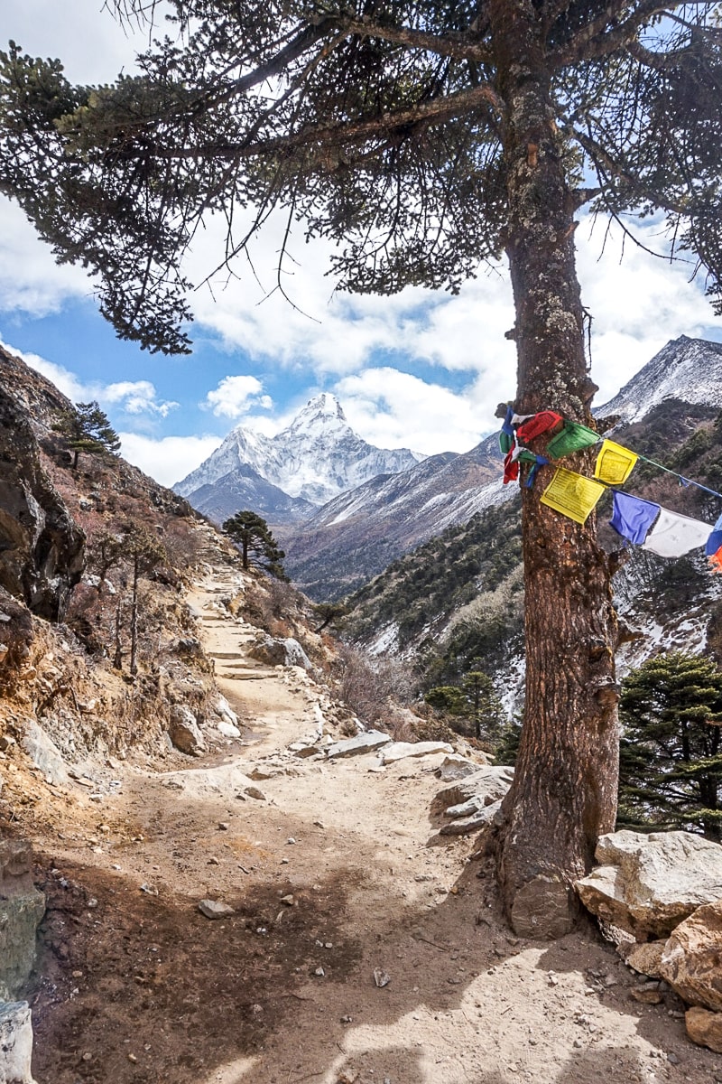 A dusty trail with the pointed Ama Dablam mountain in the background on the Everest Base Camp trek