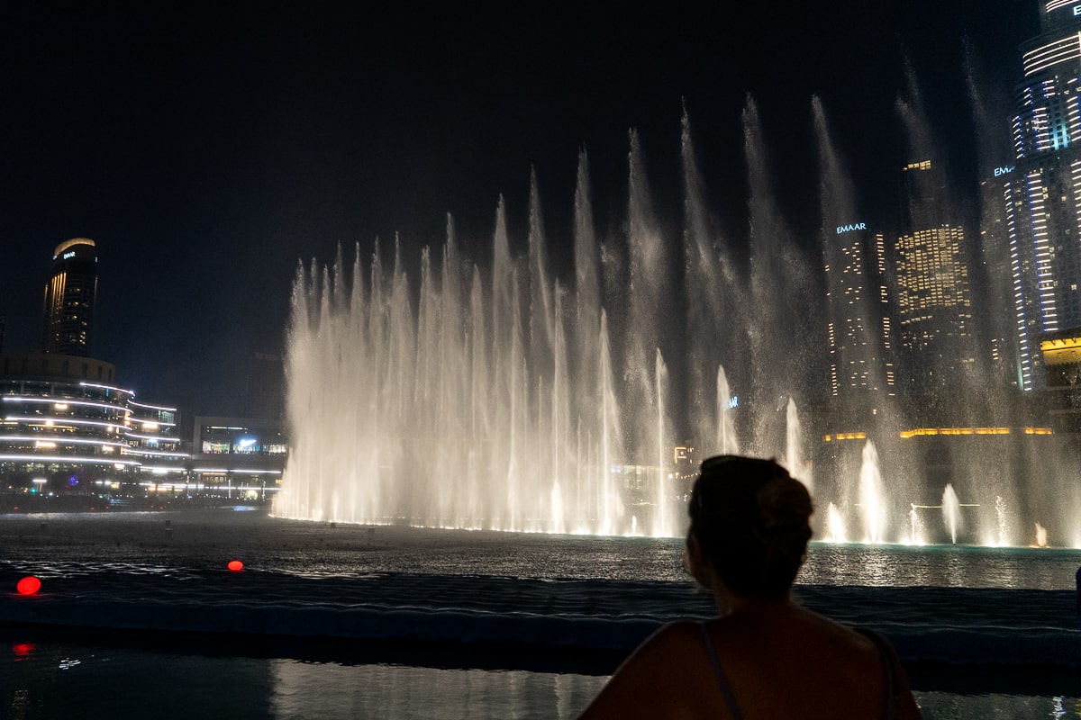 A girl watches the Dubai fountain show at night