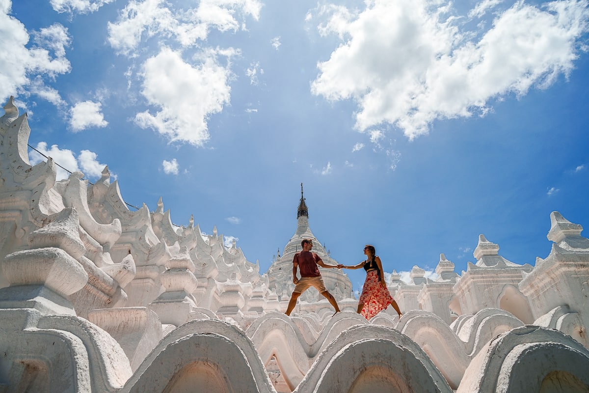 A couple hand-in-hand on a white wavy buddhist structure