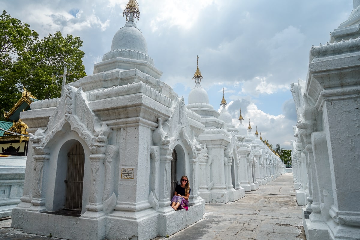 A set of small, detailed white buildings and a girl sitting in one