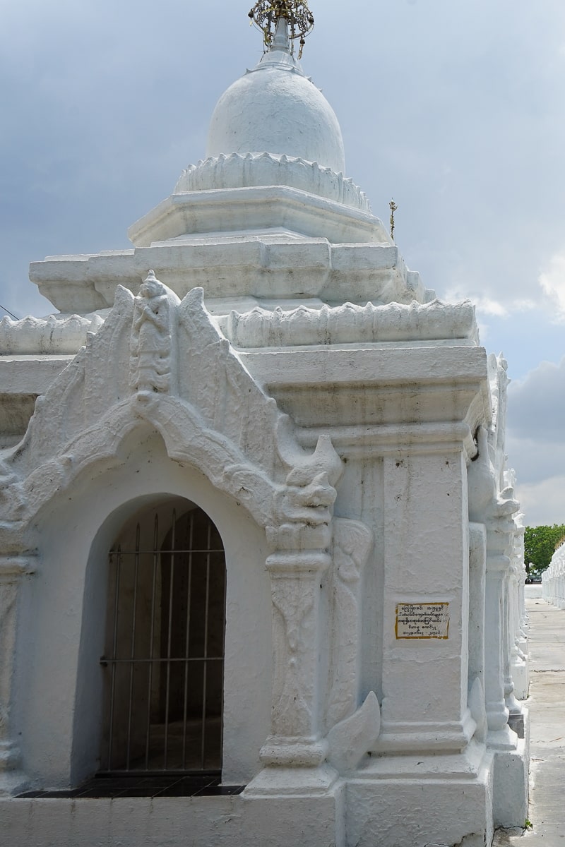 A small, detailed white building with a doorway