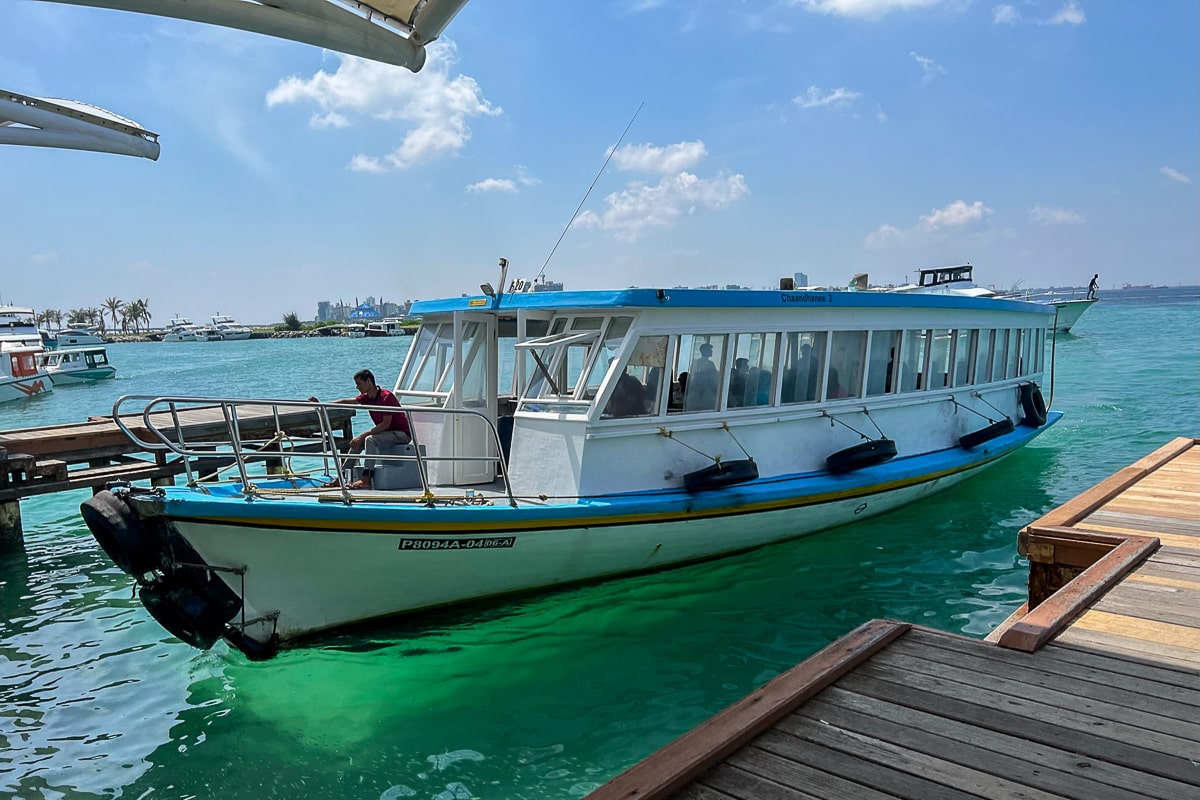 A blue and white ferry pulls into the dock at Male Airport in the Maldives