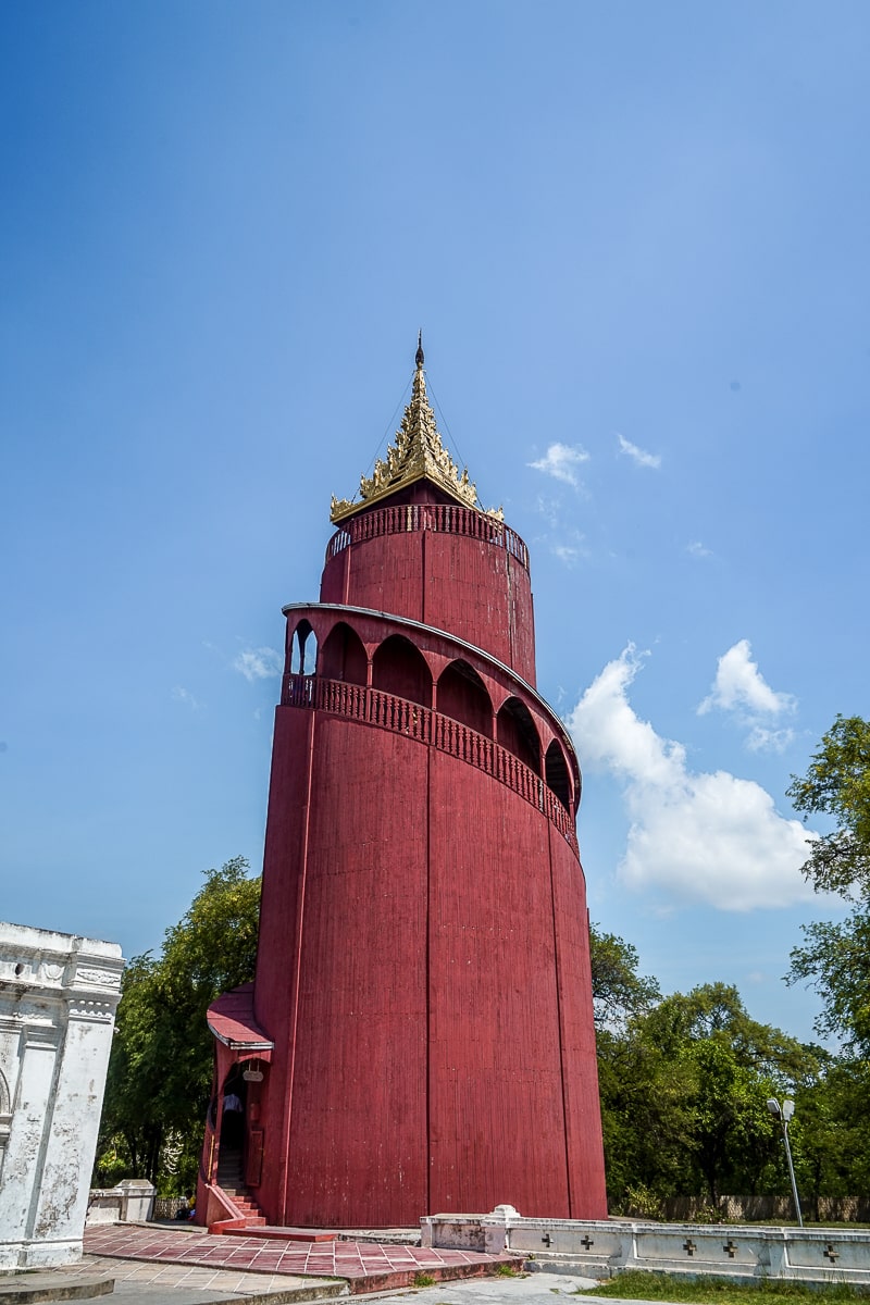 A red tower with spiral staircase around the outside and a gold pointed roof