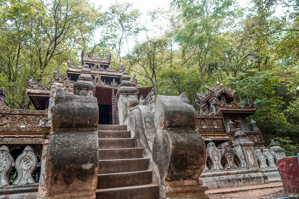 A buddhist monastery with stone steps and statues leading to it