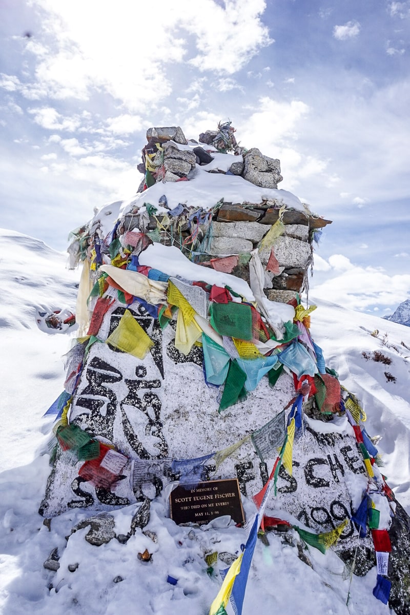 Scott Fischer's memorial site - A stone structure decorated with prayer flags and "Scott Fischer 1991" written on it - the year he died summiting Everest